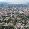 Vista panorámica de Bogotá con amplia zona residencial, edificaciones densas, avenidas principales, cerros orientales y cielo nublado asociada al pronóstico del clima.