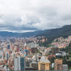 Vista panorámica de Bogotá con edificaciones densas, cerros orientales y cielo nublado amplio