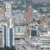 Vista panorámica de Bogotá con edificios residenciales y comerciales, corredores viales de alto tráfico, torres de gran altura y amplia concentración urbana.