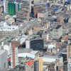 Vista aérea del centro de Bogotá con edificios, oficinas y zonas residenciales en un día soleado y despejado.