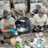 Foto que muesta dos personas con tapabocas y guantes separando residuos