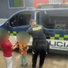 Dos niños rescatados, de la mano con un policía.