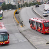 Foto de una vía de Bogotá donde se ven varios buses de TransMilenio.