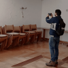 Personal del IDIGER realiza visita técnica para inspeccionar salón con daños visibles en pared, sillas apiladas y mesas laterales en unidad residencial de Bogotá.