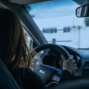 Foto de una mujer conduciendo un vehículo en una vía de Bogotá.