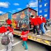 Foto que muestra un grupo de personas empujando un trailer de comidas
