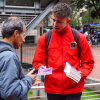 Foto de u funciionario entregando un libro a un ciudadano 