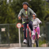 Personas recorren una ciclorruta en bicicleta durante una jornada recreativa rodeada de zonas verdes en Bogotá.