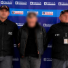 Foto que muestra un capturados y dos personas con uniforme de la Fiscalía 