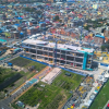 Foto que muestra un edificio en construcción y árboles 