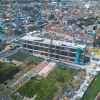 Foto que muestra un edificio en construcción y árboles 