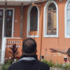 Imagen del director del IDPC con personas al frente de una casa para remodelar