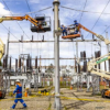 Imagen de dos técnicos de ENEL realizando trabajos en una subestación de energía.