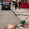 Foto que muestra una persona barriendo la calle y un camion recolector