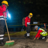 Trabajadores de una obra vial trabajando en la noche.