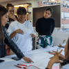 Mujeres y hombres reunidas trabajando en una mesa.