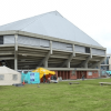 Vista exterior del Palacio de los Deportes en Bogotá con carpas institucionales, personas y un punto de recepción de ayudas humanitarias instalado sobre una zona verde.