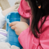 Niña jugando en el piso con un balde.