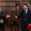 Presidente Abelardo de la Espriella y el Alcalde de Bogotá Carlos Fernando Galán, permanecen de pie frente a micrófonos en un salón con paredes de madera y estanterías al fondo.