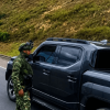 Uniformados del Ejército acercándose a una camioneta negra en una carretera.