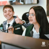 Dos estudiantes hablando por un micrófono 