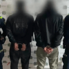 Dos hombres capturados, en medio de dos policías.