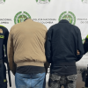 Dos 'rompevidrios' capturados, de espaldas en medio de dos Policías.