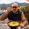 Imagen de un hombre tomando una sopa típica colombiana 'Ajiaco'