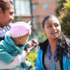 Foto de una funcionaria orientando a una madre con su bebe 