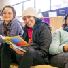 Imagen de tres mujeres sentadas con libros en las Bibliotecas Públicas de Bogotá.