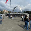 Vista exterior de Corferias en Bogotá con personas transitando por la plaza principal, el arco de acceso al centro de eventos.