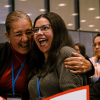 Mujeres sonriendo y abrazándose en un encuentro en Bogotá.