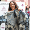 Persona sostiene una prenda elaborada con retazos textiles en una muestra sobre reciclaje de ropa.