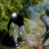 Foto que muestra dos policías y dos personas apagando una fogata 