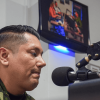 Uniformado del ejército hablando en una cabina de radio.
