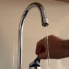 Una persona abriendo una llave de agua en una vivienda en Bogotá.