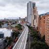 Vista de un tramo elevado de la Línea 1 del Metro de Bogotá en construcción, rodeado de edificios residenciales y de oficinas.