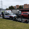 Ambulancia detenida sobre una vía de Bogotá junto a dos motocicletas caídas en el carril.