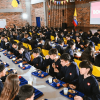 Foto que muestra estudiantes sentados dentro de un comedor escolar 
