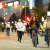 Personas en bicicleta, corriendo y caminando durante una jornada nocturna de actividad física en una vía de Bogotá.