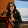 Adriana Soto, secretaria de Ambiente, participa desde un atril en foro sobre gestión de sitios contaminados.