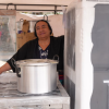 Mujer con una nevera y una olla, para apoyo a su emprendimiento en Bogotá.