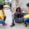 Dos funcionarios de la Secretaría de Integración Social conversando con un habitante de calle. 