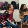 Foto que muestra dos hombres y dos mujeres sentados en escritorios dentro de un salón
