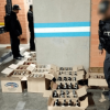 Foto que muestra cajas con licor en el piso y personal de la Fiscalía 