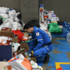 Foto que muestra una persona organizando elementos como alimentos, papel higienico y cajas
