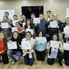 Foto que muestra un grupo de personas sonriendo con diplomas en las manos