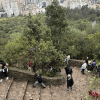 Foto de personas ascienden los escalones del sendero de Monserrate en un día despejado y con vista panorámica de Bogotá.