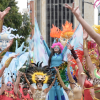 Imagen de varios artistas en las carrozas del Festival de Verano, de fondo se ve el edificio Torre Colpatria.