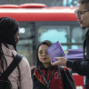 Imagen de varios jóvenes recibiendo ejemplares gratuitas de Libro al Viento en TransMilenio.